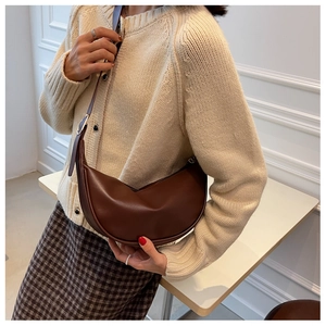 Detail view of a vintage dark brown crescent bag worn with a casual knit cardigan