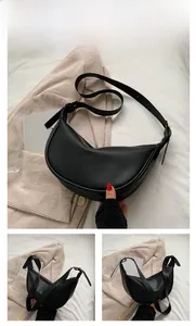 Detail view of a black minimalist crescent moon shoulder bag with adjustable strap