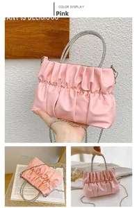 Close-up of pink pleated handbag with rhinestone-encrusted handle and metal chain