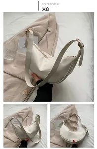Detail of off-white crescent moon shoulder bag with gold buckle and smooth leather finish