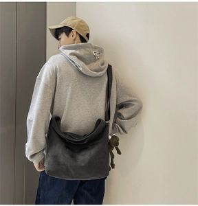 Close-up of canvas tote bag with HOOD lettering print and green frog plush charm