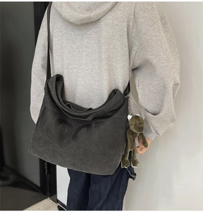 Detail of dark grey canvas tote bag with MOOD text print and a green frog plush charm