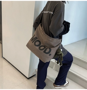 Detail of coffee brown canvas shoulder bag with MOOD text and green frog plush charm