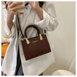 Close-up of caramel crocodile texture crossbody bag with braided ring handle detail