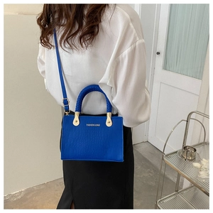 Blue crocodile texture handbag with woven handle and gold fashion lettering detail