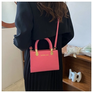 Detail of rose pink crossbody bag with crocodile texture and fashion text for women