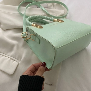 Detail showing the bottom of the mint green crocodile pattern leather handbag with gold metal