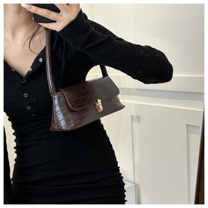 Detail of dark brown faux crocodile skin shoulder bag with gold rectangular metal lock
