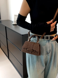 Deep brown hourglass mini bag with embossed woven texture shown on model
