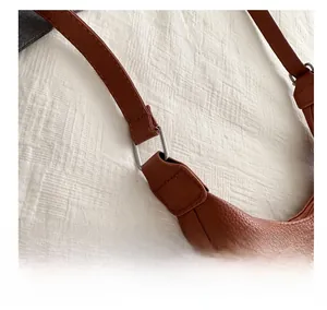 Détails du sac en cuir marron grainé avec boucles métalliques carrées argentées sur l'anse