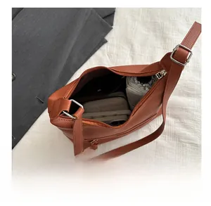 Vue de dessus du grand cabas en cuir marron montrant l'intérieur spacieux et les accessoires