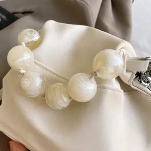 Detail shot of ivory soft leather cloud bag featuring large marble pattern pearl handle