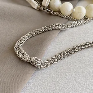 Macro shot of silver woven chain strap with marble bead detail and metallic clasps