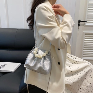 Detail of silver pleated bucket bag with large pearl handle and metal chain strap