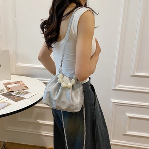 Silver metallic dumpling bag with large pearl handle shown on model for size and fit