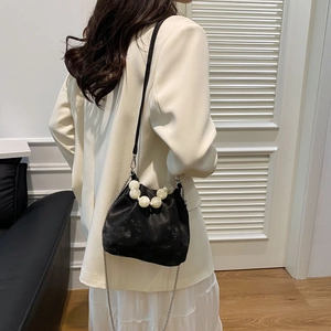 Detail of black cloud bucket bag with marble handle and fine silver chain strap