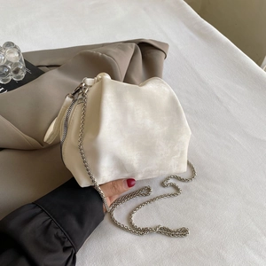 Detailed close-up of cream cloud bag featuring smooth matte texture and silver chain strap