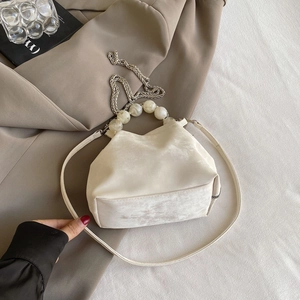 Detail of macaron off-white cloud bag with pearl handle and metal chain strap