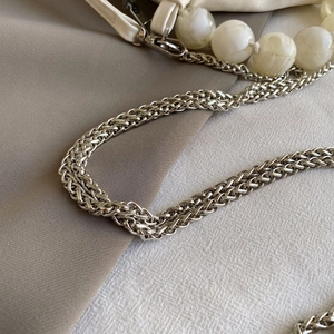 Detail of silver chain strap with white marble beads and faux leather attachment
