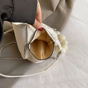 Detail view of the beige cloud bag interior with soft lining and gold zipper closure