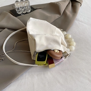Internal storage detail of cloud bag showing phone, sunglasses, and lipstick inside