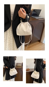 Detail of off-white cloud bag with oversized pearl handle and metal chain shoulder strap