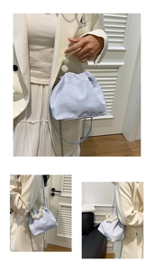 Detail of light blue dumpling bag with large marble beads handle and silver chain strap