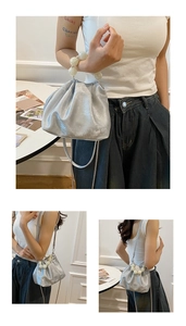 Detail of silver cloud bag with oversized pearl handle and metallic chain strap