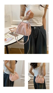 Detail of pink soft pleated cloud bag featuring large pearl handle and crossbody chain strap