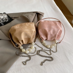 Detail of macaron pearl handle and matte pleated texture on elegant cloud crossbody bags
