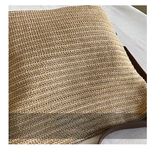 Detailed close-up of natural straw weaving texture with a dark brown leather strap