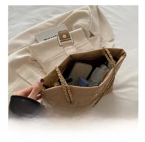 Dettaglio della borsa shopper trapuntata beige che mostra la capienza per oggetti quotidiani