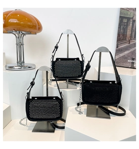 Chic black PU leather shoulder bags with silver rivet detailing on a display shelf