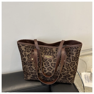Gros plan sur le sac fourre-tout léopard avec étiquette en cuir brun et tissu texturé
