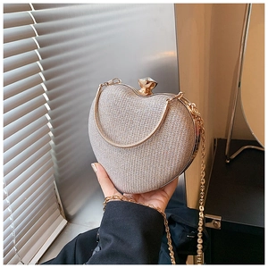 Dettaglio pochette a cuore glitter argento con chiusura a gemma dorata e catenina
