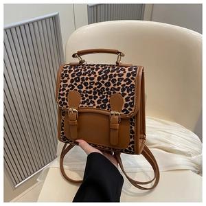 Detailed view of the leopard print mini backpack with brown faux leather and metal buckles