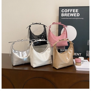 Detailed close-up of glossy hobo bags in five colors with stylish decorative bows