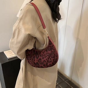 Red leopard print crescent shoulder bag with gold hardware and slim leather strap