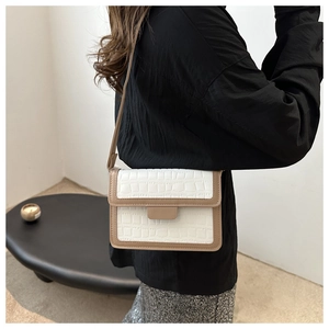 Detailed view of crocodile texture pattern and contrast stitching on crossbody square bag
