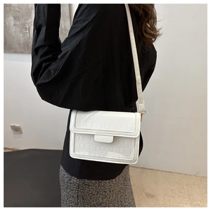 Stylish white crocodile pattern crossbody flap bag shown as a shoulder bag on a model