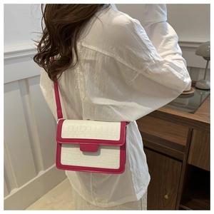 Detail of white crocodile pattern crossbody bag with rose red leather straps and trim