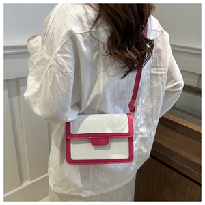 Detail of a pink and white patchwork crossbody bag with premium crocodile skin texture