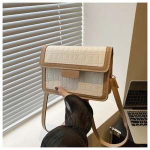 Detail of structured rectangular crossbody bag with cream and brown crocodile texture