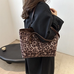 Large leopard print tote bag with brown faux leather straps and gold metal studs