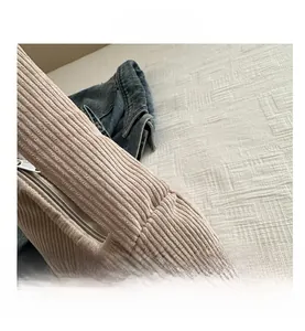 Detail view of beige corduroy shoulder bag showing vertical texture and zipper closure