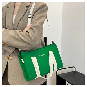 Détail du sac cabas en toile verte montrant sa grande capacité et sa bandoulière réglable