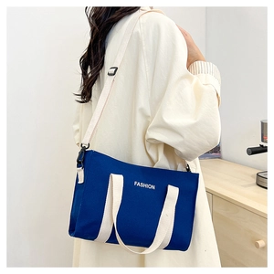 Détail du sac fourre-tout en toile bleu marine avec imprimé FASHION et anses crème