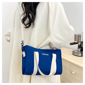 Sac cabas bleu en toile avec imprimé FASHION blanc et bandoulière amovible porté