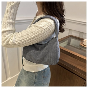 Detail of grey blue corduroy hobo bag texture showing the soft fabric and shoulder wear style
