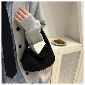 Detail of black corduroy texture and sturdy zipper closure on this casual shoulder bag